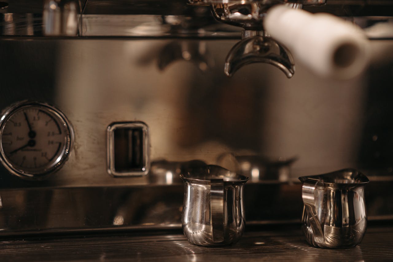 Detailed view of an espresso machine with metal pitchers, perfect for coffee enthusiasts.